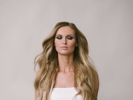 Beautiful woman long hair blonde natural portrait with beauty makeup. Studio shot.の写真素材