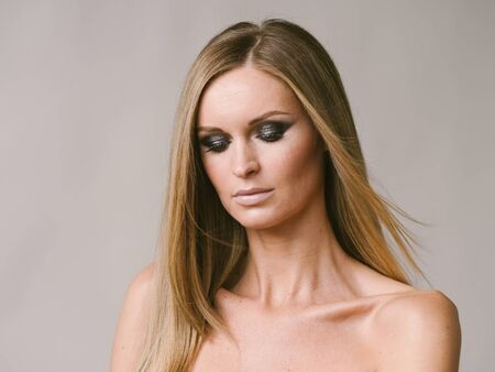 Beautiful woman long hair blonde natural portrait with beauty makeup. Studio shot.の写真素材