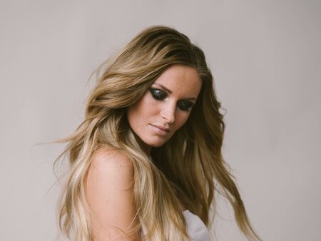 Beautiful woman long hair blonde natural portrait with beauty makeup. Studio shot.の写真素材