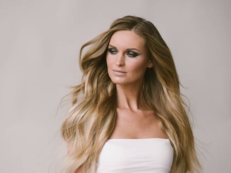 Beautiful woman long hair blonde natural portrait with beauty makeup. Studio shot.の写真素材