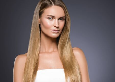 Beauty woman face healthy beautiful skin and blond smooth hair. Studio shot.の写真素材