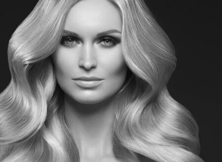 Healthy curly hair woman long blonde hairstyle female. Studio shot. Monochrome. Gray. Black and white.の写真素材