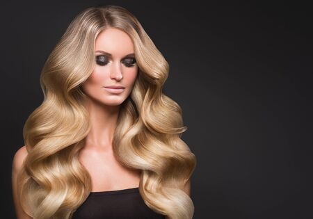 Blond woman long hair curly natural fashion makeup. Studio shot.の写真素材