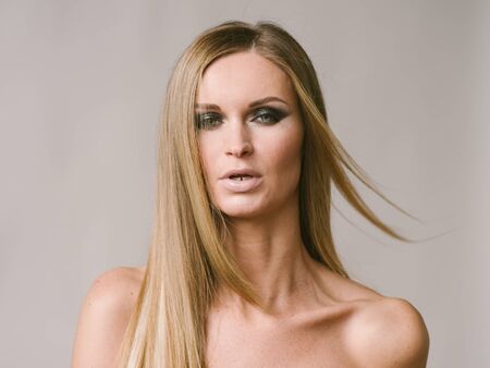 Beautiful woman long hair blonde natural portrait with beauty makeup. Studio shot.の写真素材