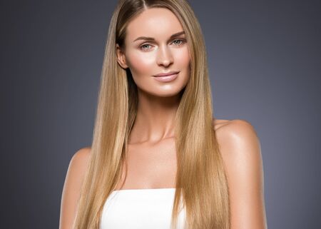 Beauty woman face healthy beautiful skin and blond smooth hair. Studio shot.の写真素材