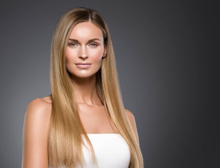 Beauty woman face healthy beautiful skin and blond smooth hair. Studio shot.の写真素材