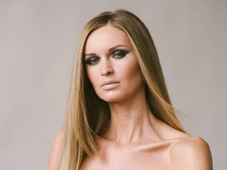 Beautiful woman long hair blonde natural portrait with beauty makeup. Studio shot.の写真素材