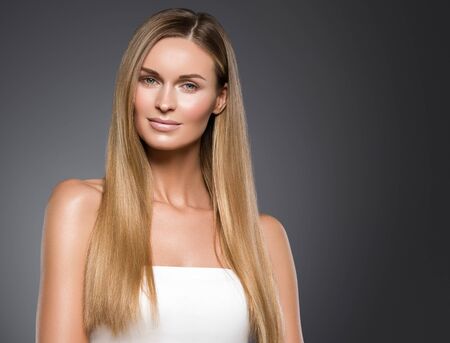 Beauty woman face healthy beautiful skin and blond smooth hair. Studio shot.の写真素材