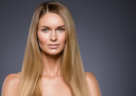 Beauty woman face healthy beautiful skin and blond smooth hair. Studio shot.の写真素材