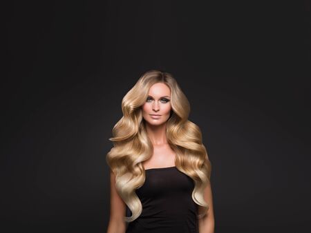 Blond woman long hair curly natural fashion makeup. Studio shot.の写真素材