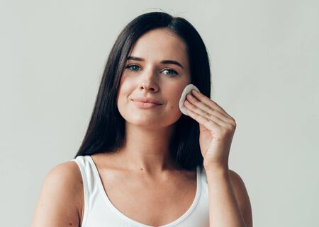 Cotton pad woman face remove makeup healthy skin natural makeup.  Studio shot.の写真素材