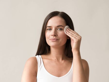 Cotton pad woman face remove makeup healthy skin natural makeup.  Studio shot.の写真素材