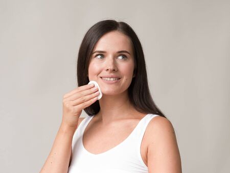 Cotton pad woman face remove makeup healthy skin natural makeup.  Studio shot.の写真素材