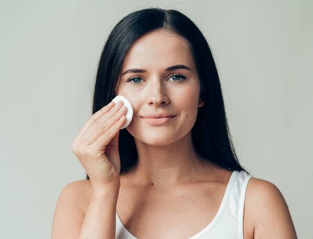 Cotton pad woman face remove makeup healthy skin natural makeup.  Studio shot.の写真素材