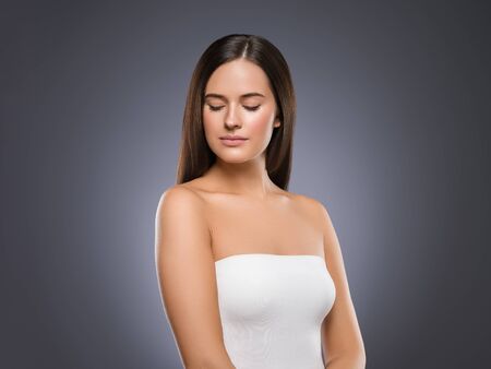 Beauty face woman young beautiful girl Gorgeous female portrait brown hair. Young adult girl with healthy skin fashion eye makeup. Studio shot.の写真素材