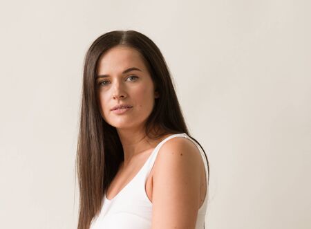 Natural brunette woman long hair casual makeup. Studio shot.の写真素材