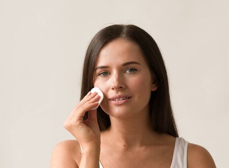 Cotton pad woman face remove makeup healthy skin natural makeup.  Studio shot.の写真素材