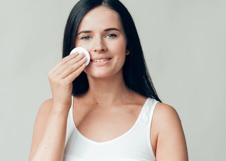Cotton pad woman face remove makeup healthy skin natural makeup.  Studio shot.の写真素材