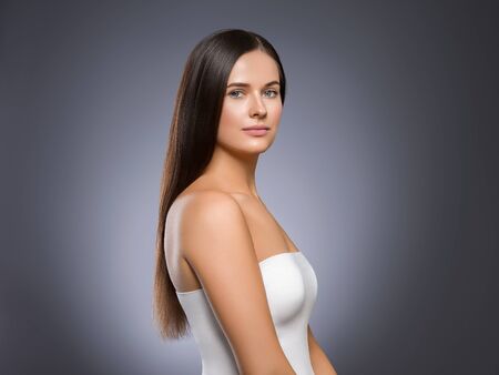 Beauty face woman young beautiful girl Gorgeous female portrait brown hair. Young adult girl with healthy skin fashion eye makeup. Studio shot.の写真素材