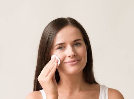 Cotton pad woman face remove makeup healthy skin natural makeup.  Studio shot.の写真素材
