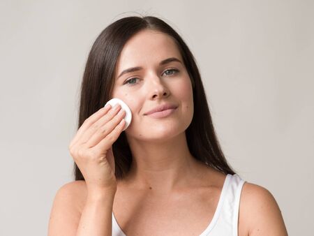 Cotton pad woman face remove makeup healthy skin natural makeup.  Studio shot.の写真素材