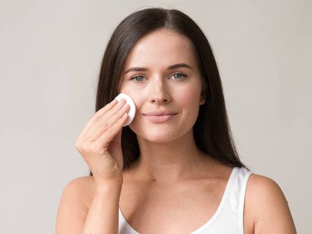 Cotton pad woman face remove makeup healthy skin natural makeup.  Studio shot.の写真素材