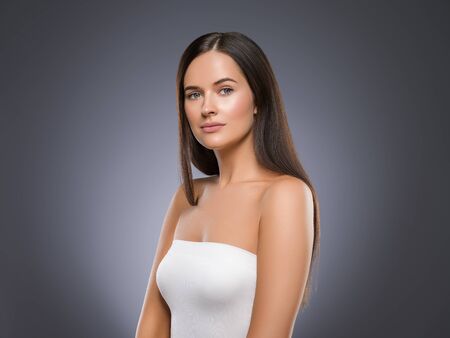 Beauty face woman young beautiful girl Gorgeous female portrait brown hair. Young adult girl with healthy skin fashion eye makeup. Studio shot.の写真素材