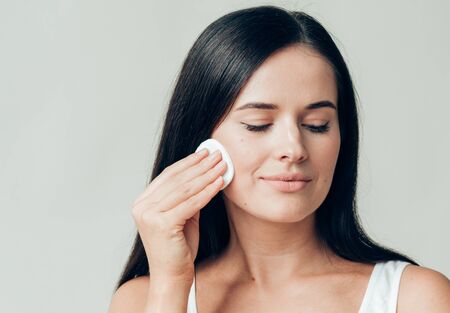 Cotton pad woman face remove makeup healthy skin natural makeup.  Studio shot.の写真素材