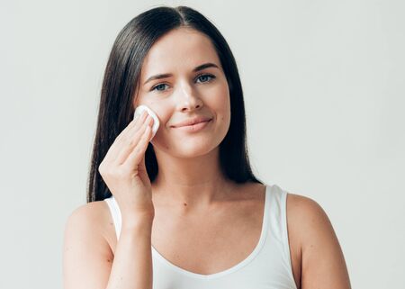 Cotton pad woman face remove makeup healthy skin natural makeup.  Studio shot.の写真素材