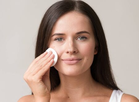 Cotton pad woman face remove makeup healthy skin natural makeup.  Studio shot.の写真素材