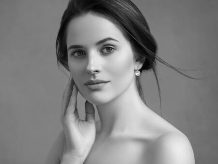 Beautiful woman portrait beauty hair and skin makeup young model. Studio shot. Monochrome. Gray. Black and white.の写真素材