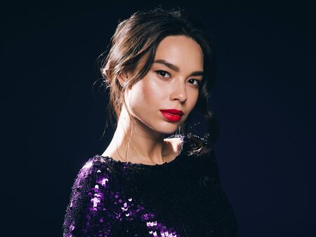 Woman in sequin dress night club concept red lips asian beauty. Studio shot.の写真素材