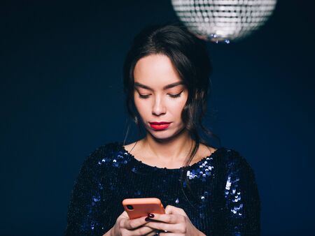 Woman in sequin dress night club concept red lips asian beauty. Studio shot.の写真素材
