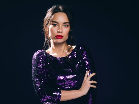 Woman in sequin dress night club concept red lips asian beauty. Studio shot.の写真素材