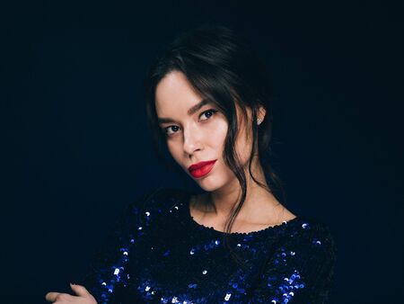 Woman in sequin dress night club concept red lips asian beauty. Studio shot.の写真素材