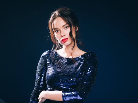 Woman in sequin dress night club concept red lips asian beauty. Studio shot.の写真素材