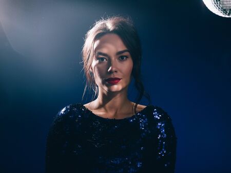 Woman in sequin dress night club concept red lips asian beauty. Studio shot.の写真素材