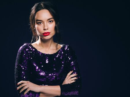 Woman in sequin dress night club concept red lips asian beauty. Studio shot.の写真素材