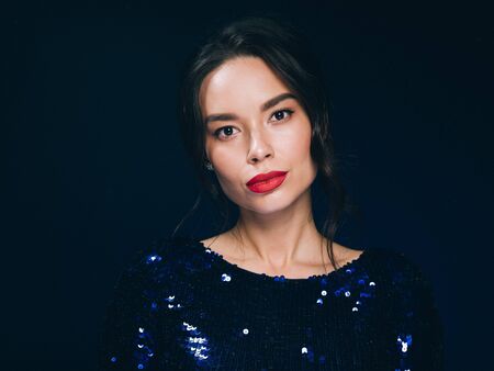 Woman in sequin dress night club concept red lips asian beauty. Studio shot.の写真素材