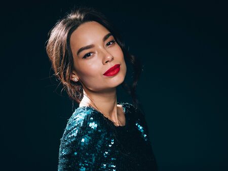 Woman in sequin dress night club concept red lips asian beauty. Studio shot.の写真素材