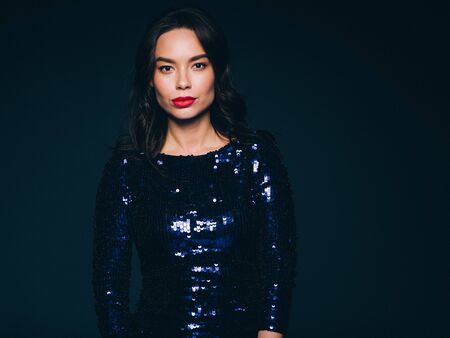 Woman in sequin dress night club concept red lips asian beauty. Studio shot.の写真素材