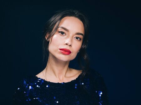Woman in sequin dress night club concept red lips asian beauty. Studio shot.の写真素材