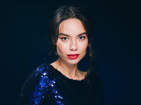 Woman in sequin dress night club concept red lips asian beauty. Studio shot.の写真素材