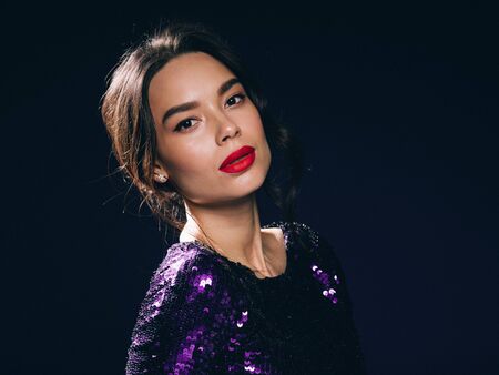 Woman in sequin dress night club concept red lips asian beauty. Studio shot.の写真素材