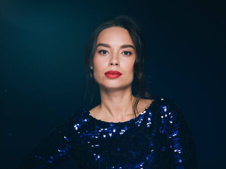 Woman in sequin dress night club concept red lips asian beauty. Studio shot.の写真素材