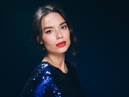 Woman in sequin dress night club concept red lips asian beauty. Studio shot.の写真素材