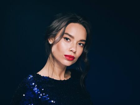 Woman in sequin dress night club concept red lips asian beauty. Studio shot.の写真素材