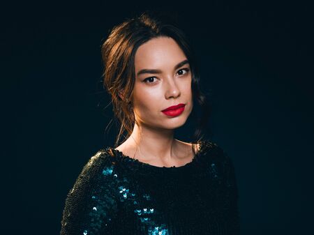 Woman in sequin dress night club concept red lips asian beauty. Studio shot.の写真素材