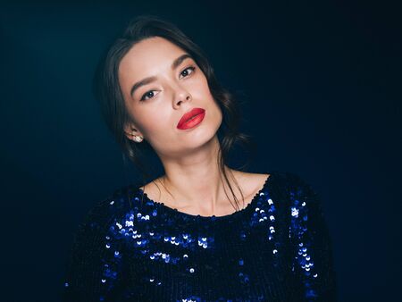Woman in sequin dress night club concept red lips asian beauty. Studio shot.の写真素材