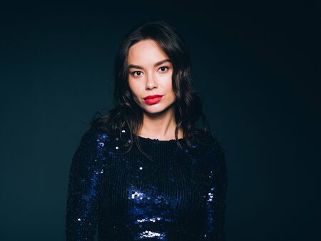 Woman in sequin dress night club concept red lips asian beauty. Studio shot.の写真素材